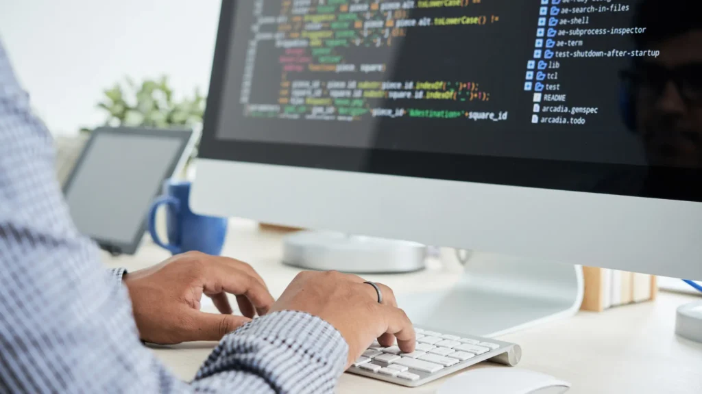 Web developer coding on a desktop computer — web development cost in Dubai