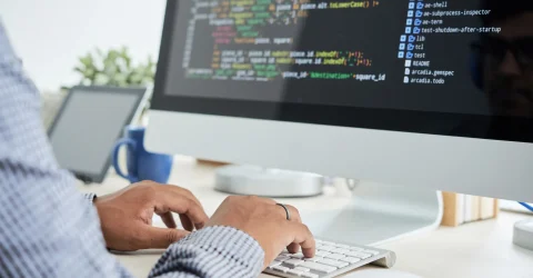 Web developer coding on a desktop computer — web development cost in Dubai